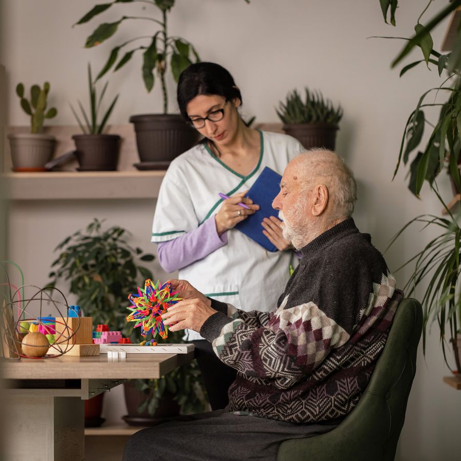A caregiver assisting an elderly client with mobility support at home
