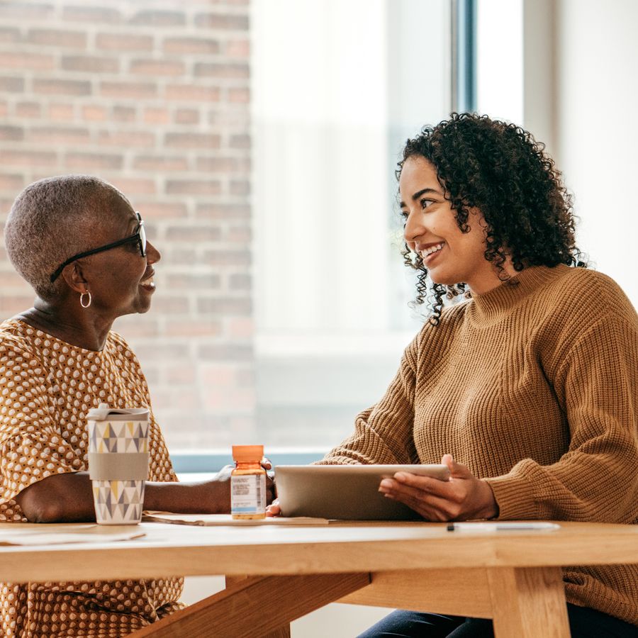 A caregiver and client laughing together during a home visit