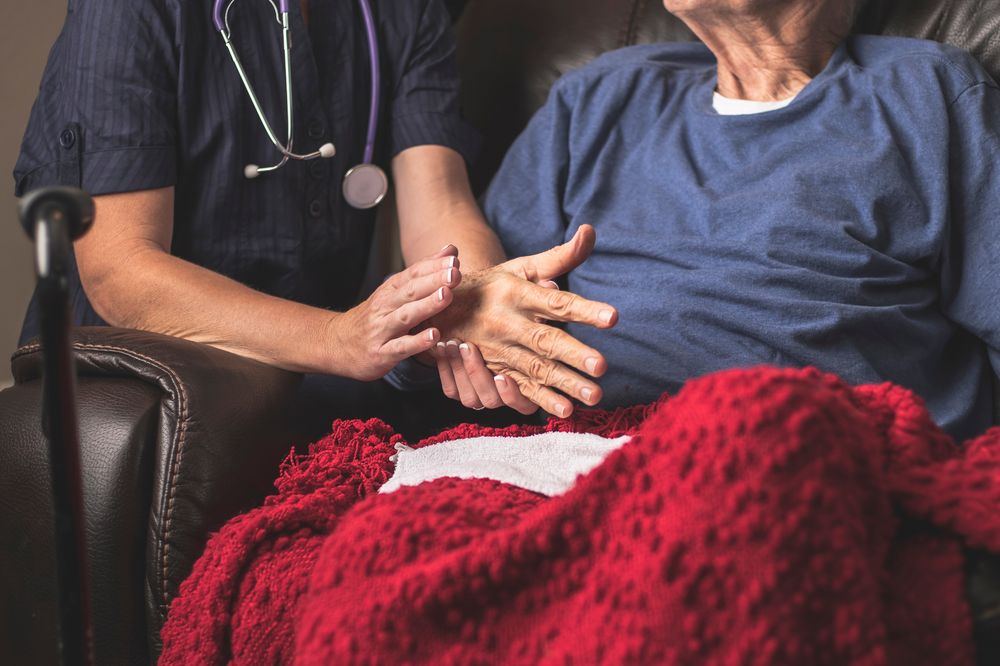 A Jaama nurse checking on a client resting comfortably at home